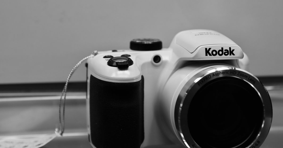 Closeup image of a Kodak camera in black and white showcasing its lens and design.